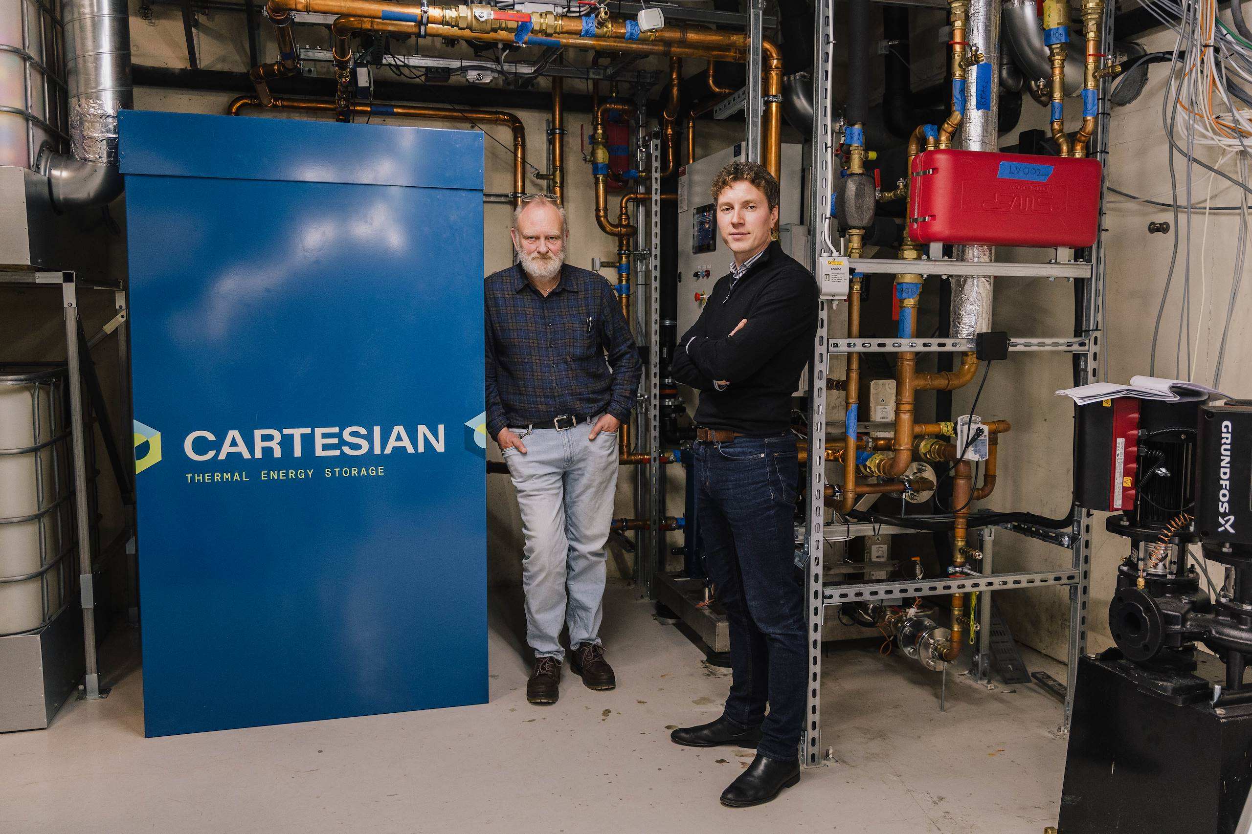 Gert Nielsen and Håkon Selvnes beside Cartesian's blue Thermal Box in Solstrand's plant room
